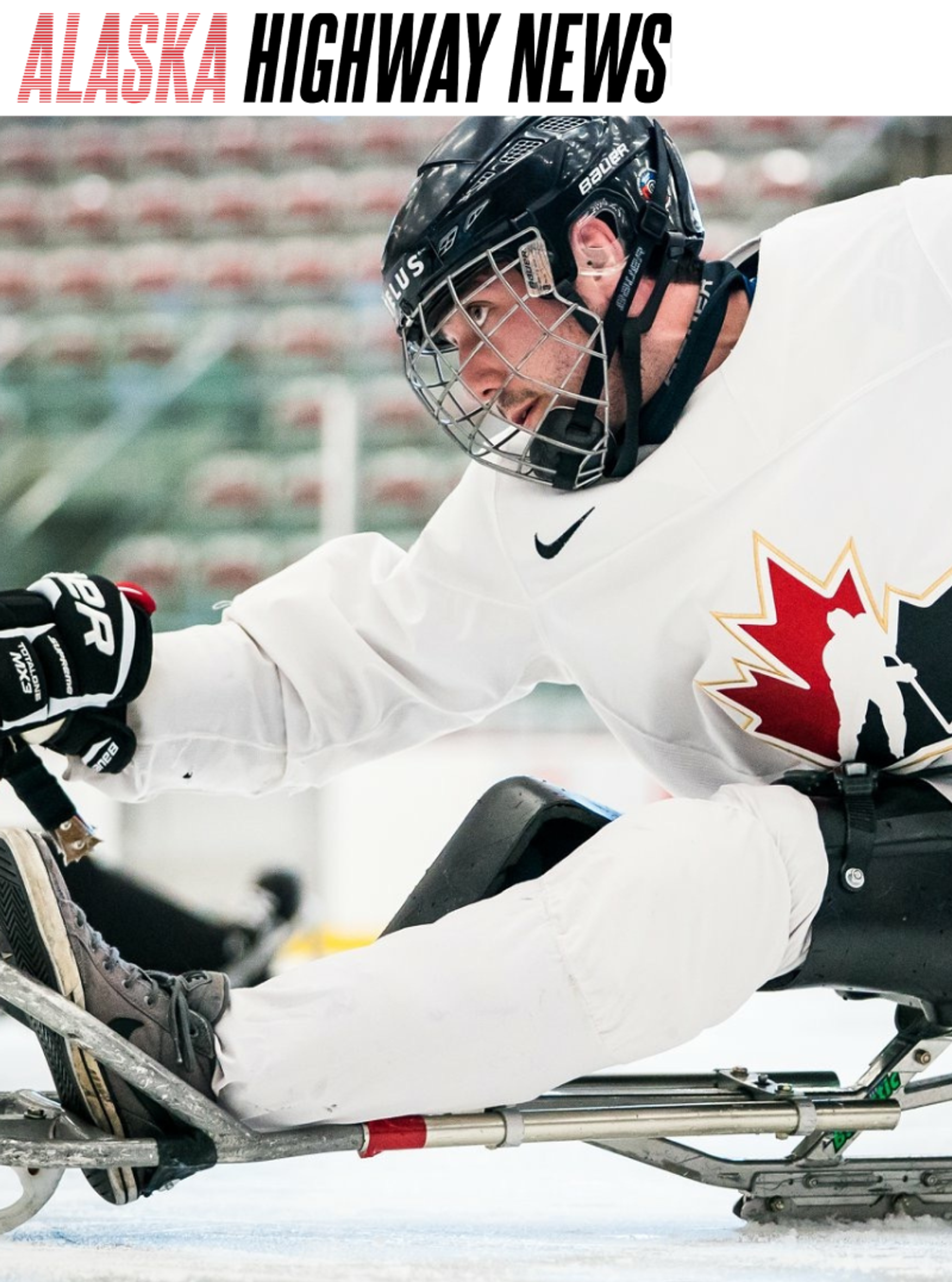 A Team Canada para hockey player pushes forward on a sled during a game, featured in Alaska Highway News.
