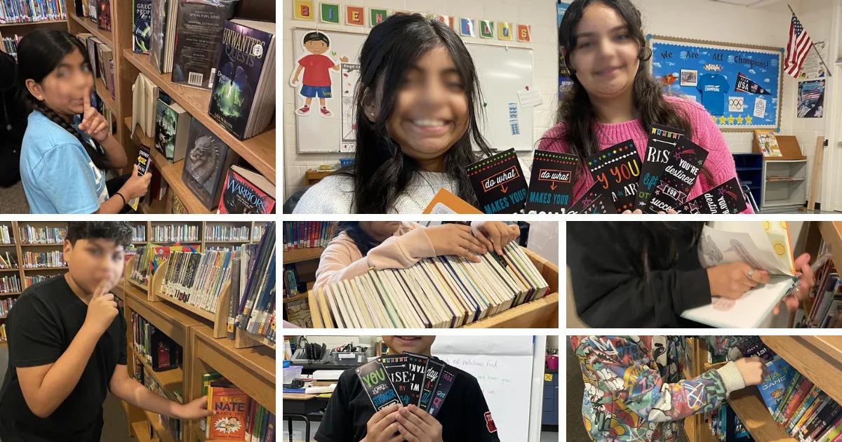 Students in a classroom library browse books and hold up motivational bookmarks they made for a service project.