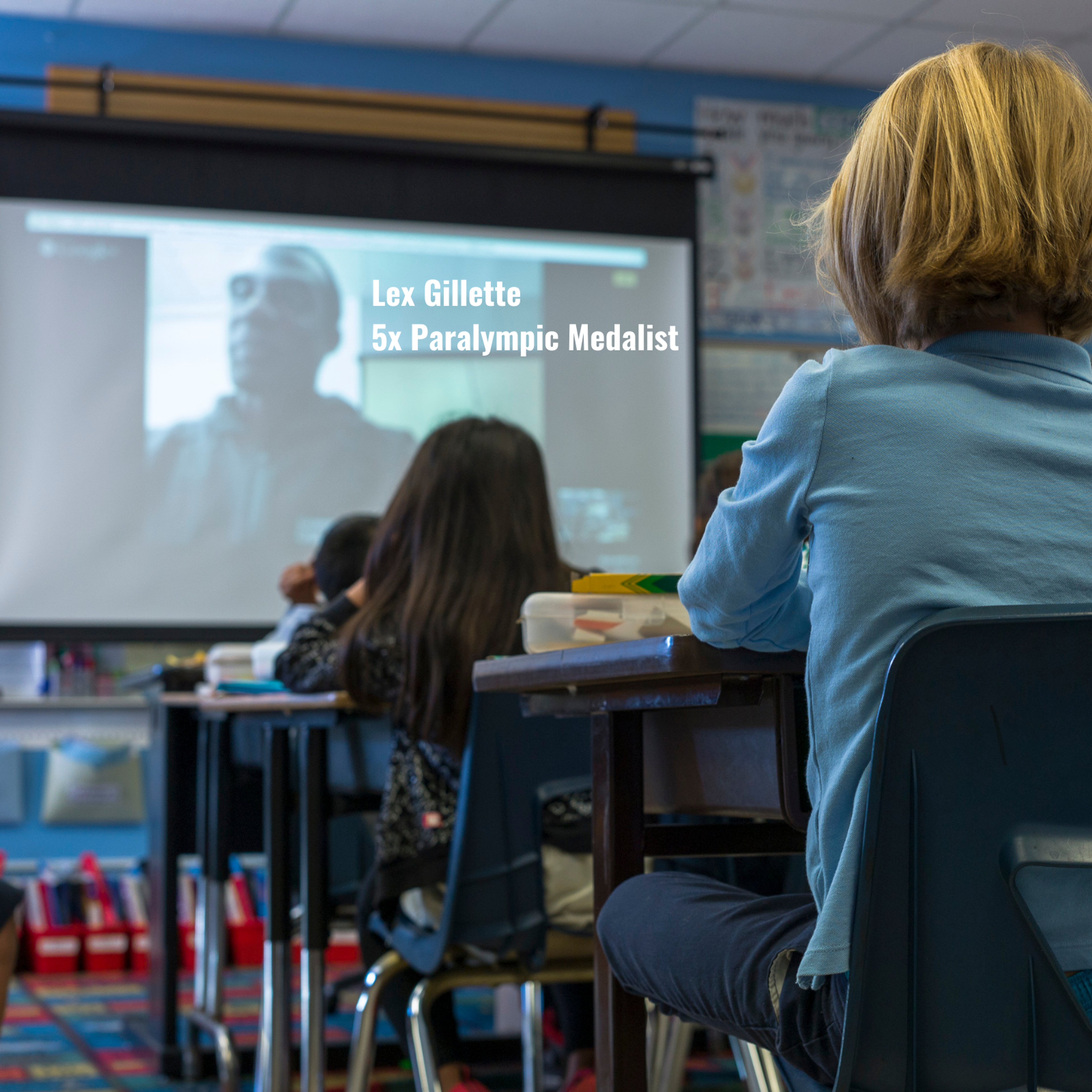 Students watch a video call with 5x Paralympic medalist Lex Gillette on a classroom screen.