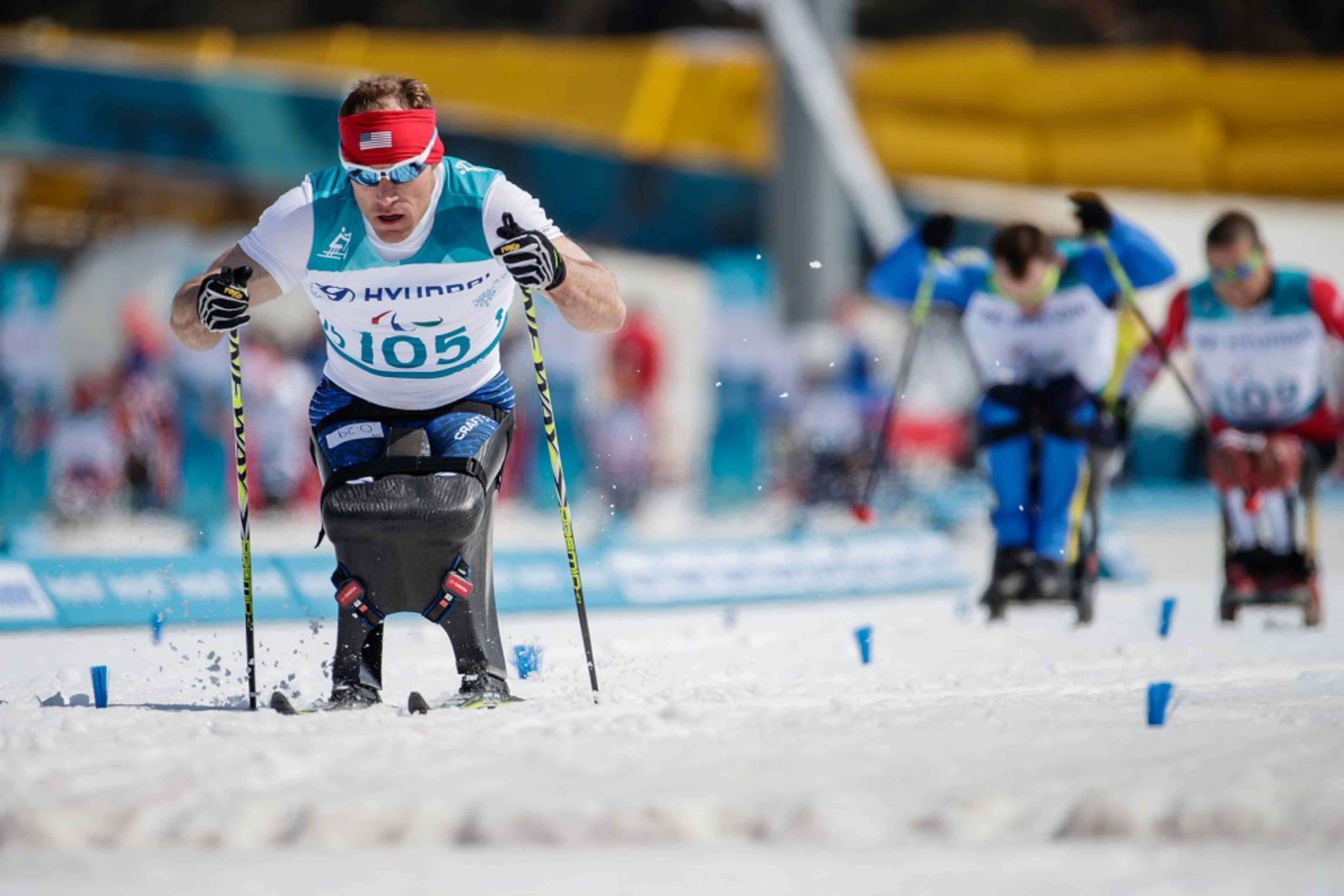 Dan Cnossen races in a sit-ski during a Paralympic cross-country skiing competition.