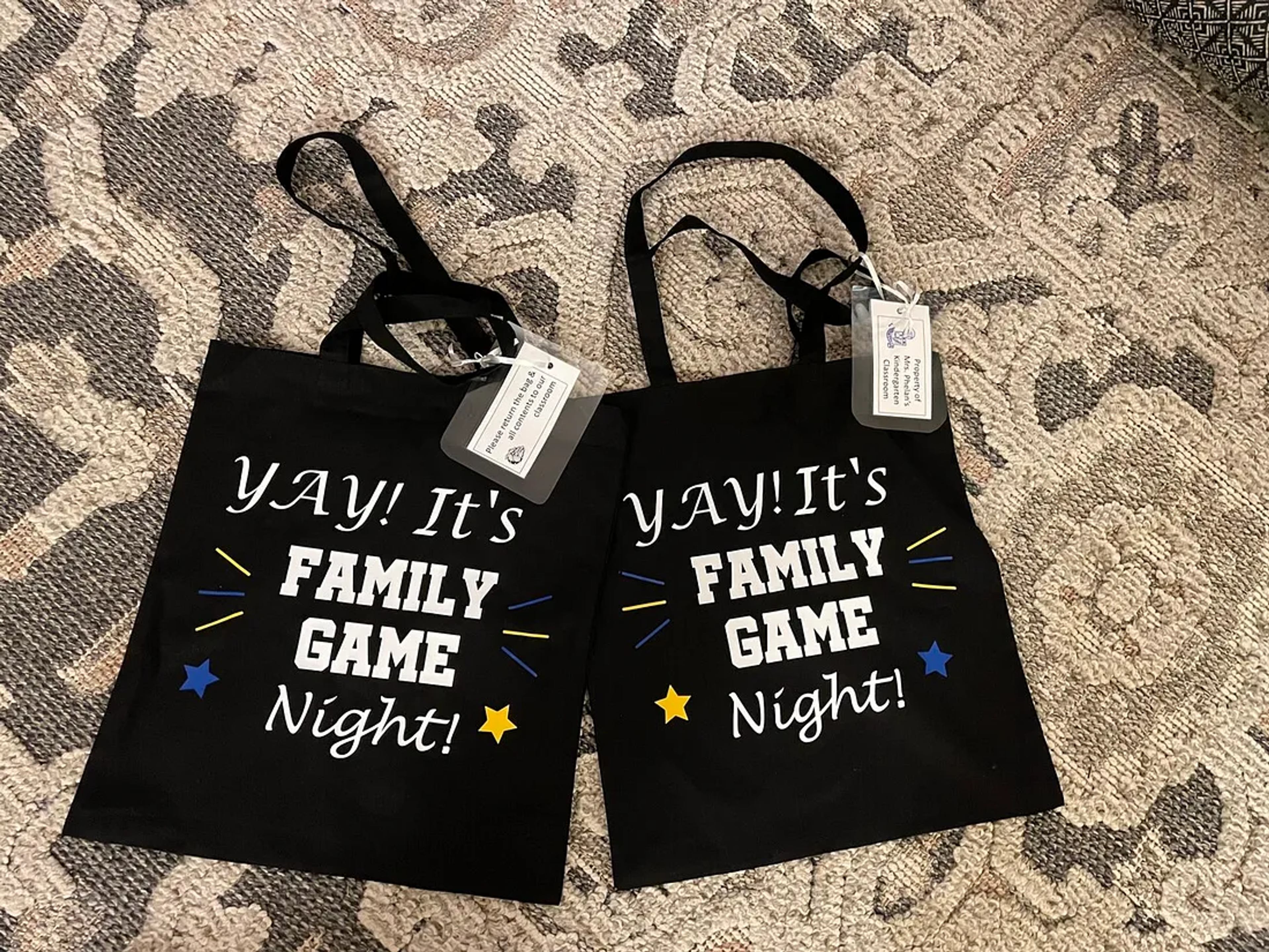 Two black tote bags printed with "Yay! It's Family Game Night!" for a classroom service learning project.