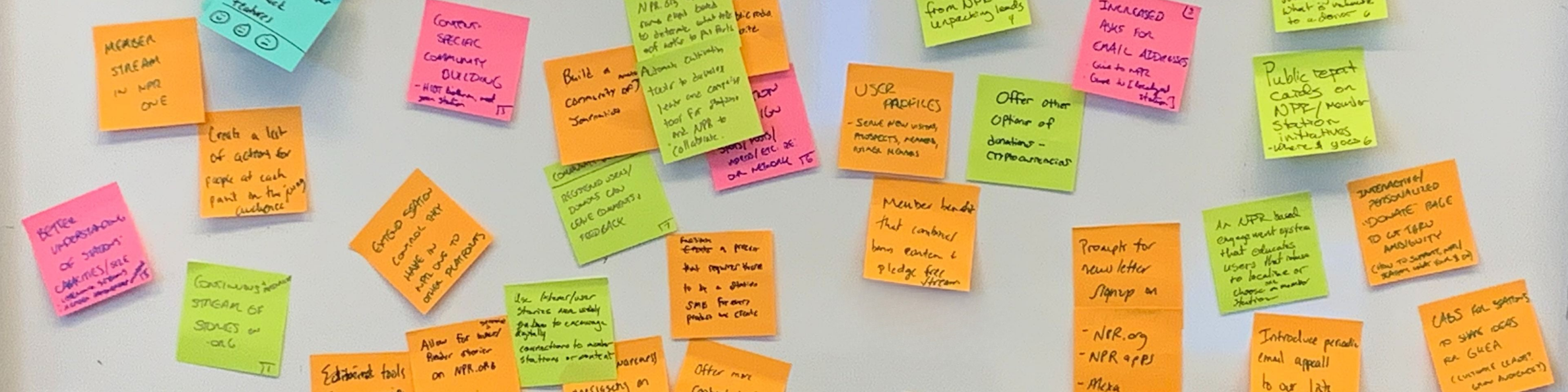 A whiteboard covered in colorful sticky notes brainstorming community-building and engagement ideas.