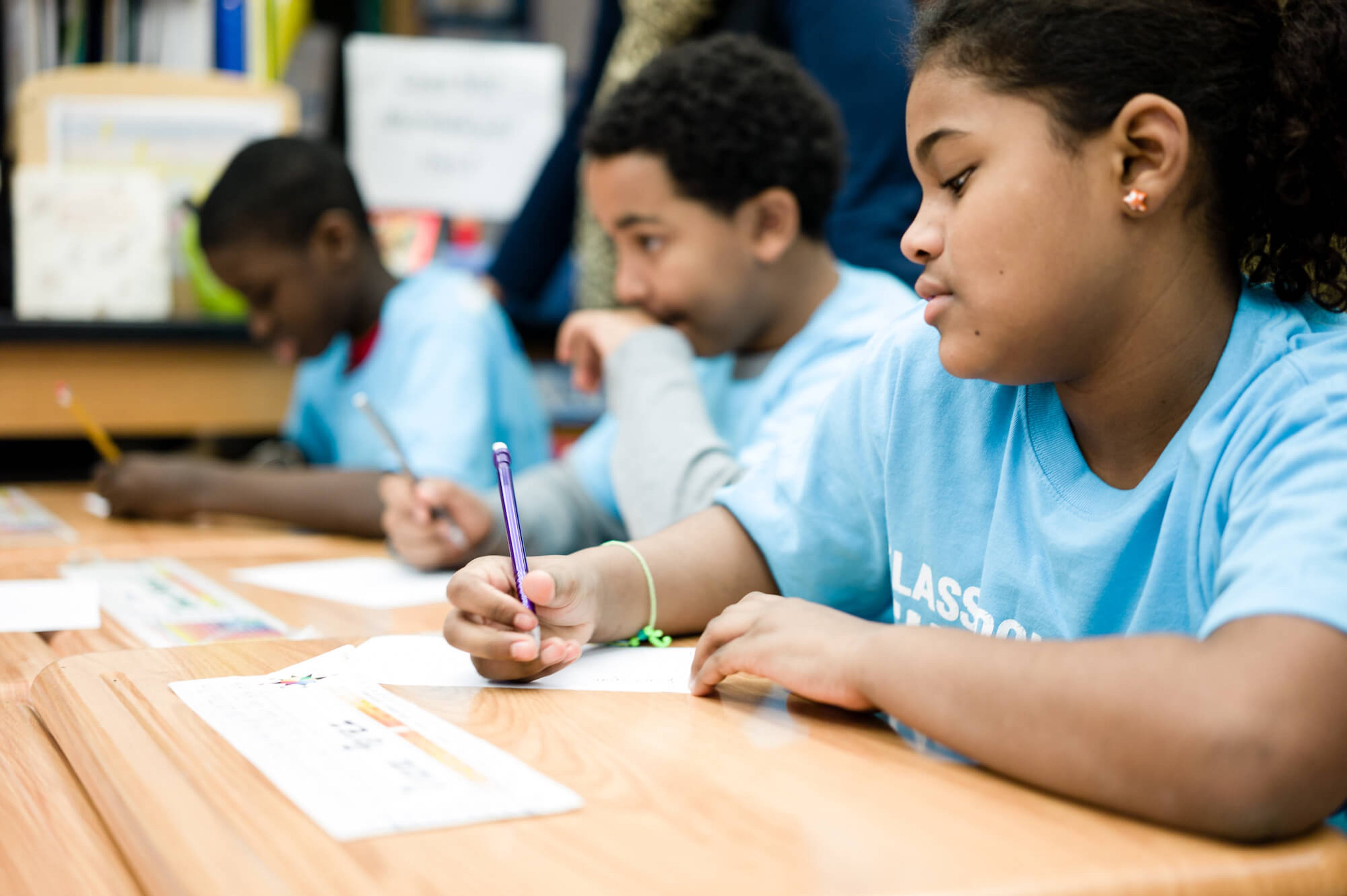 Students writing with colorful pencils