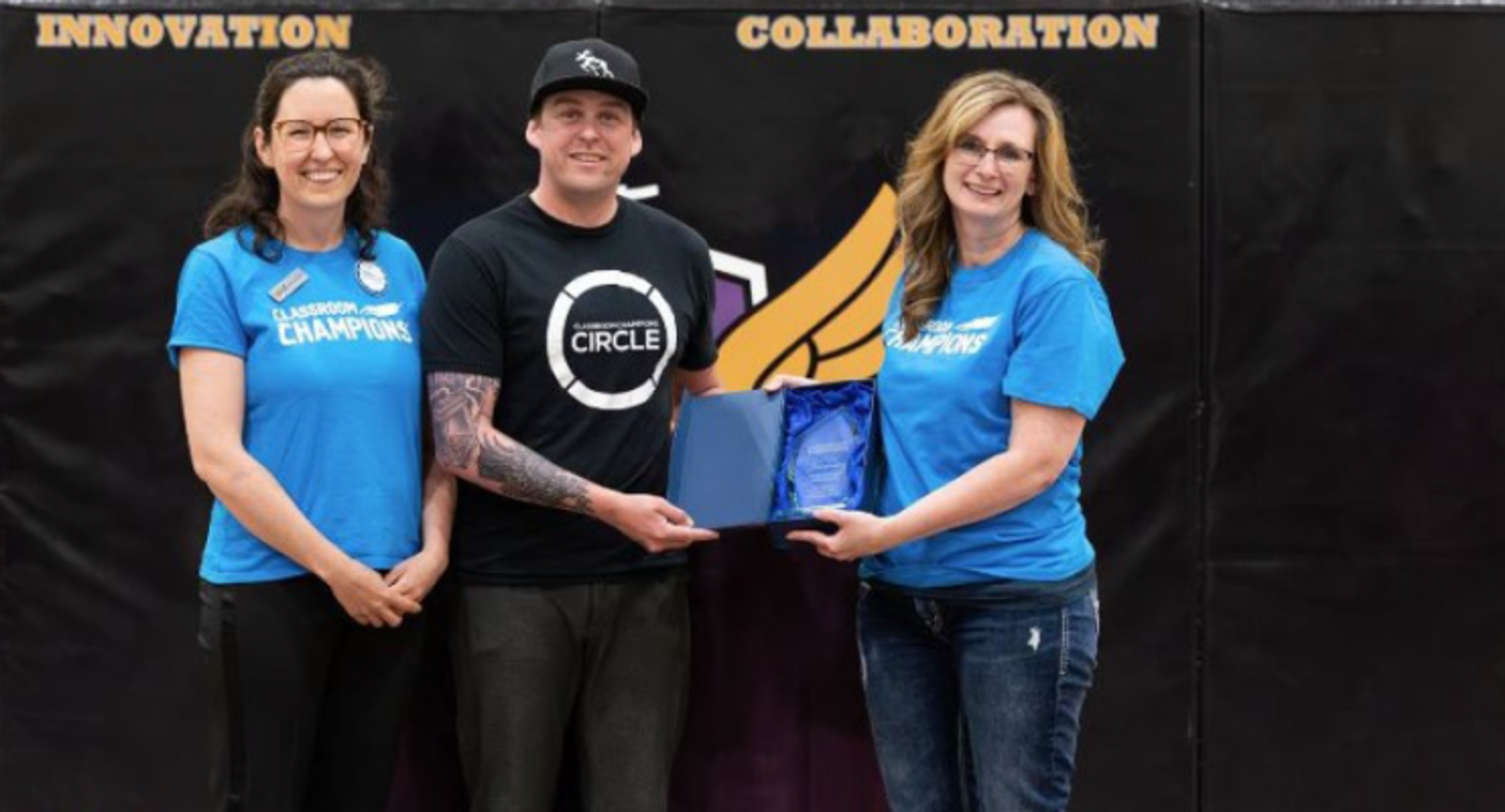 A teacher receives an award from Classroom Champions representatives at an innovation and collaboration event.