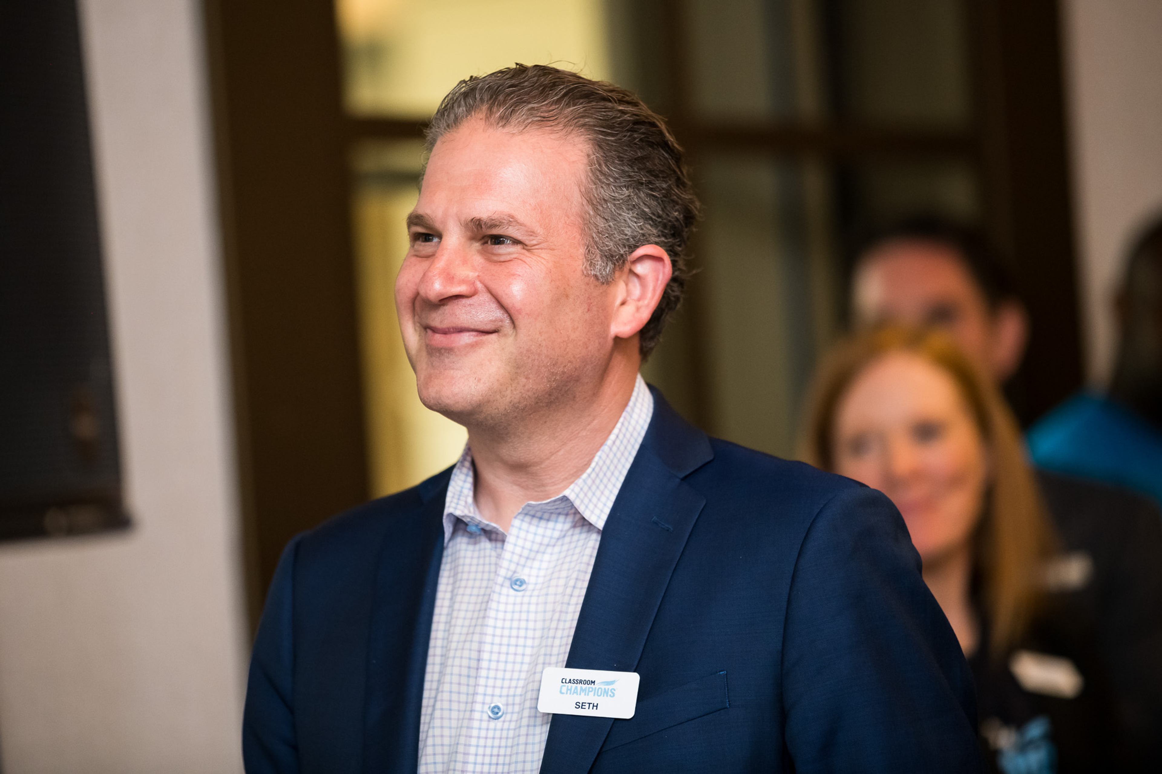 Seth Rosenzweig smiling at a Classroom Champions event, wearing a name badge.