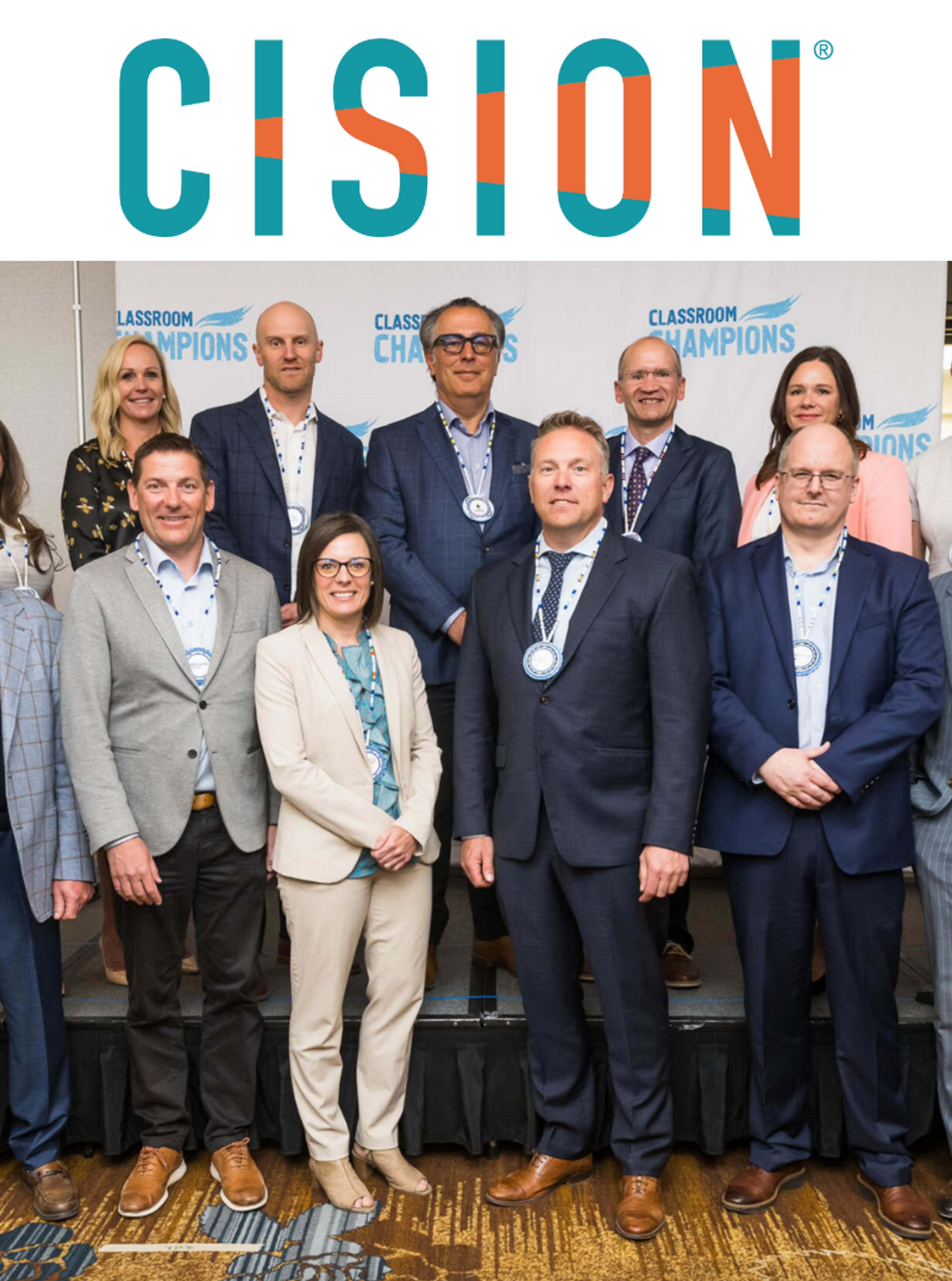 Cision logo above a group photo of medal-wearing supporters at a Classroom Champions event.