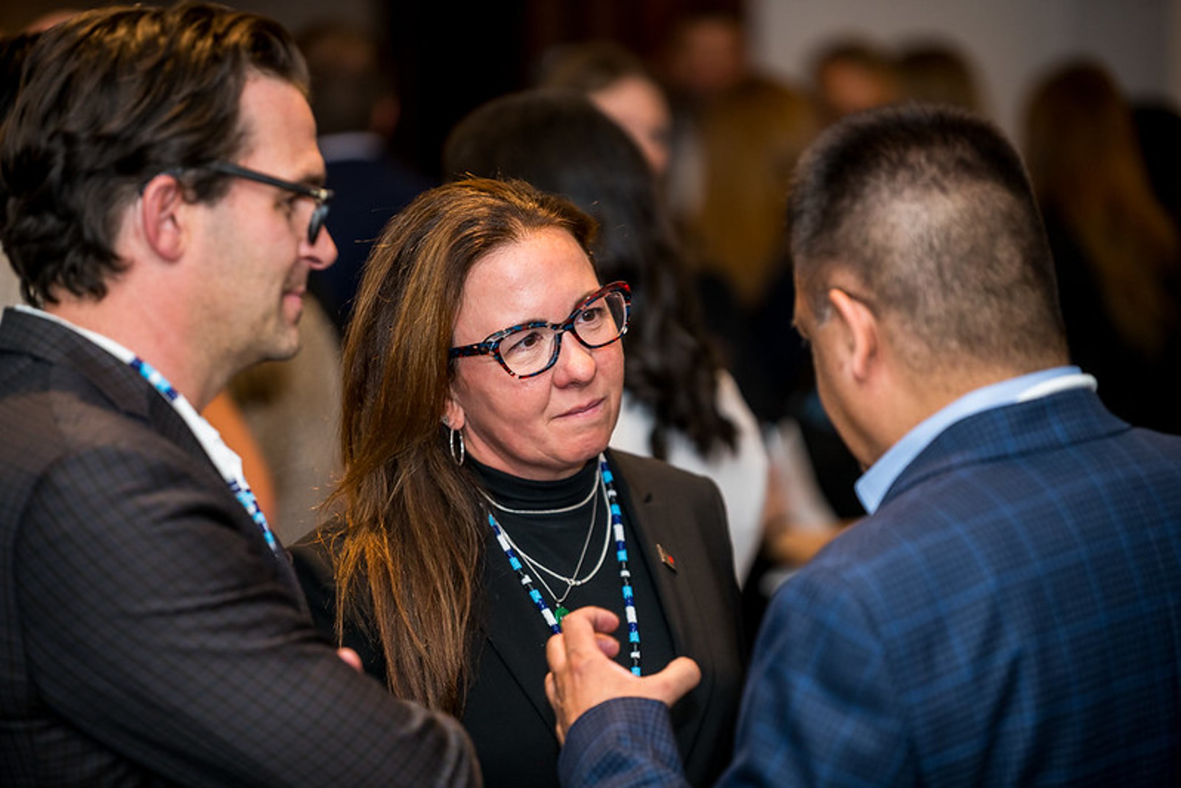 Attendees network in conversation at a Champions Circle event.