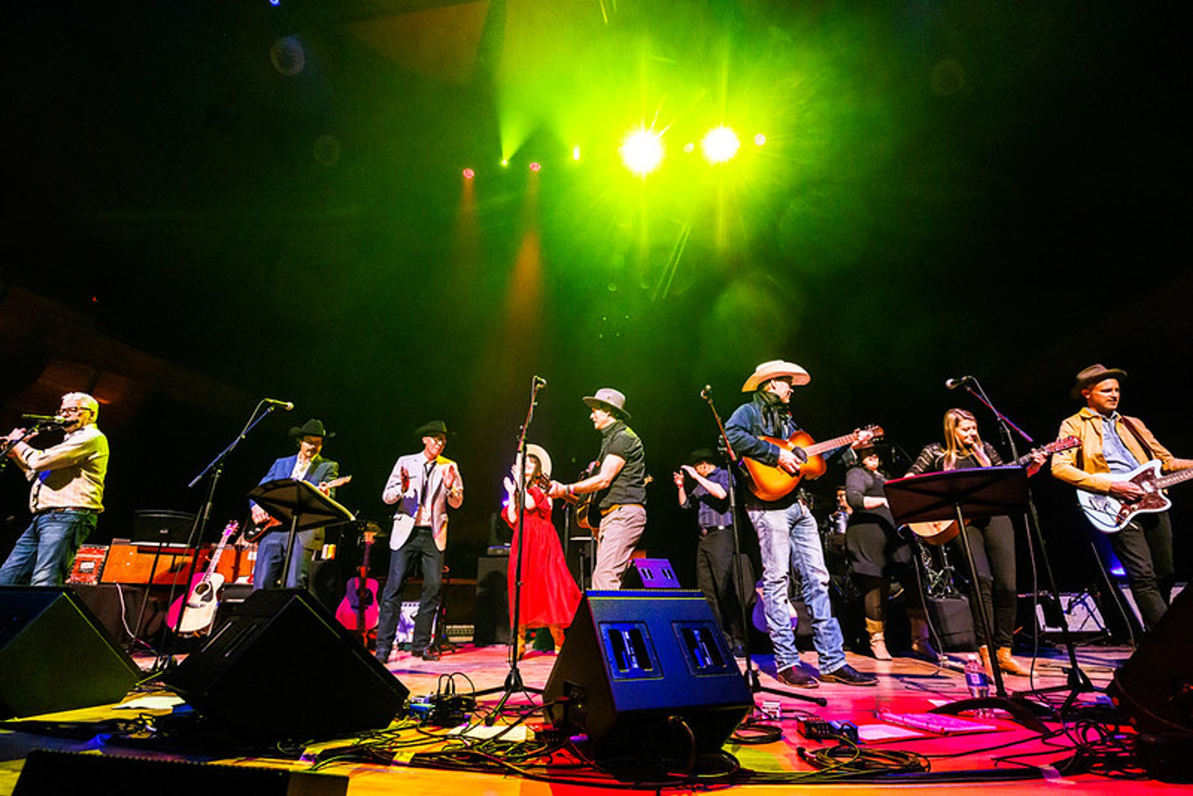 A band performs live on stage with guitars and vocals during a Concert for Classrooms fundraising event.