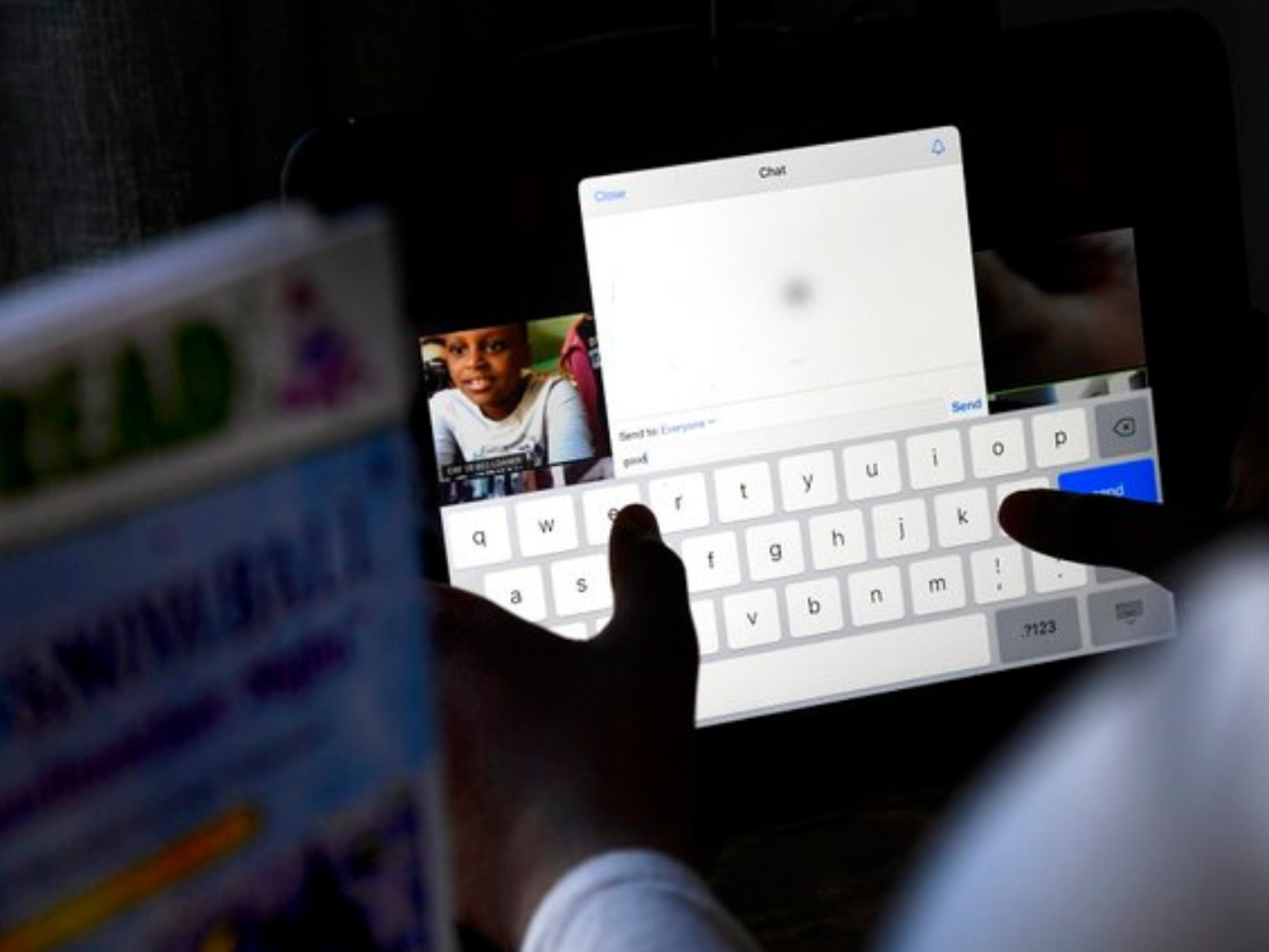 A student types a message during a live video chat with a mentor on a tablet.