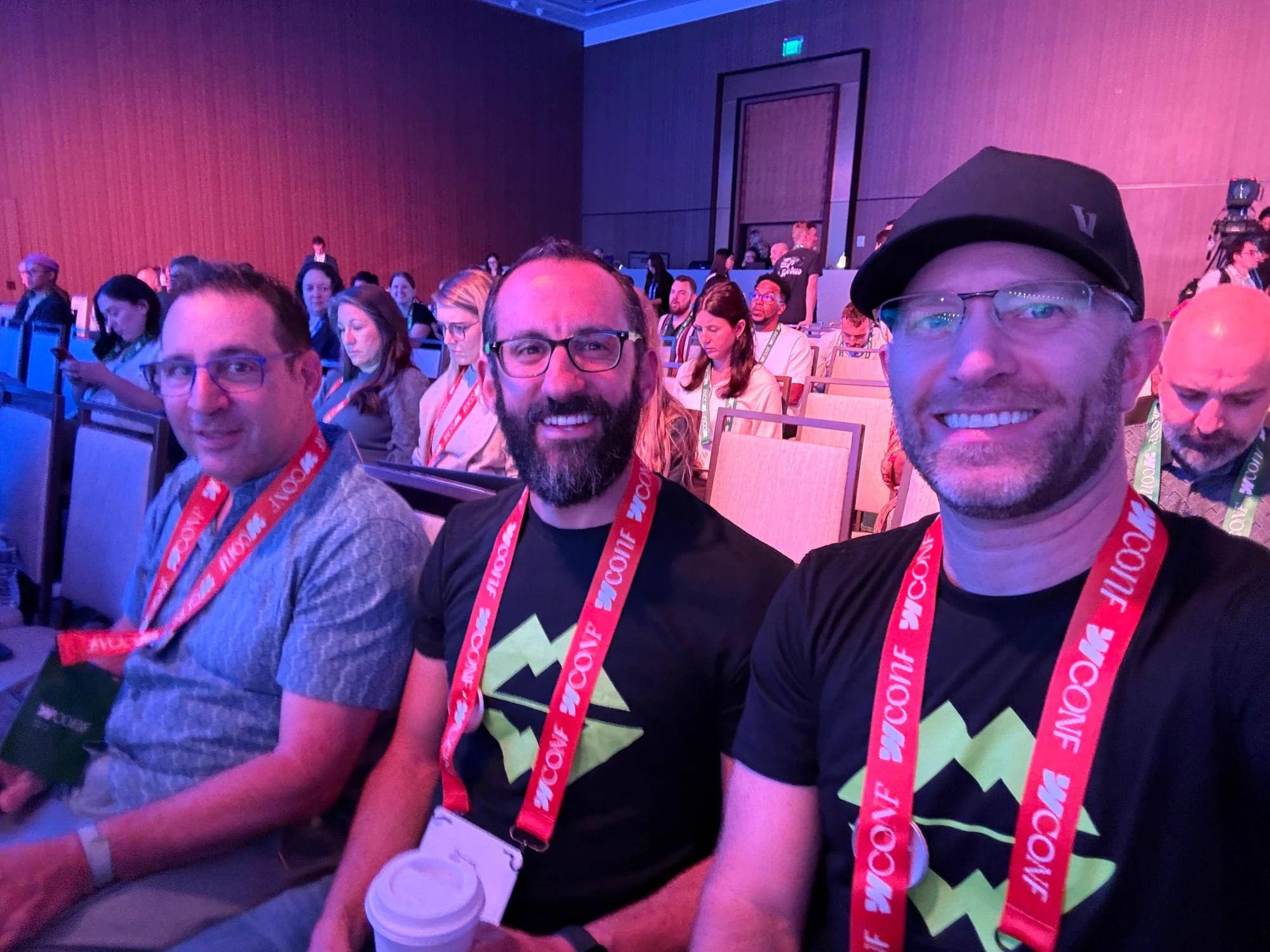Three Scaler team members Jack (left), David (middle) and Jesse (right) seated at Webflow Conf 2026 wearing conference lanyards, with other attendees in the background.