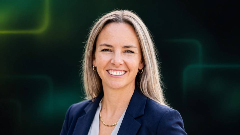 Portrait of Mary Keough smiling in a navy blazer.