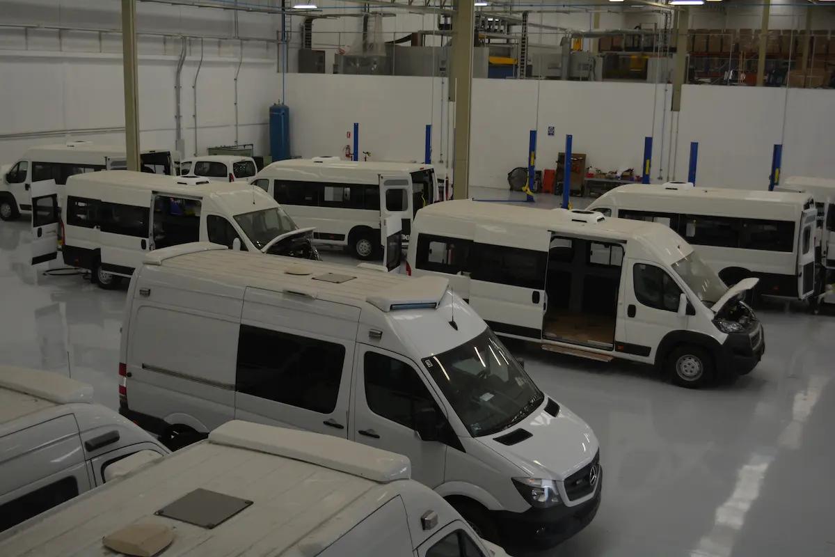 Vans blancas en taller con puertas abiertas