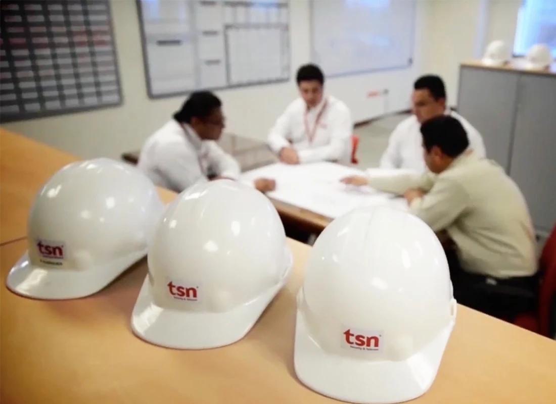 Equipo en reunión con cascos TSN sobre mesa