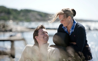 Outdoor scene with caregiver interacting beside Carony wheelchair system near water