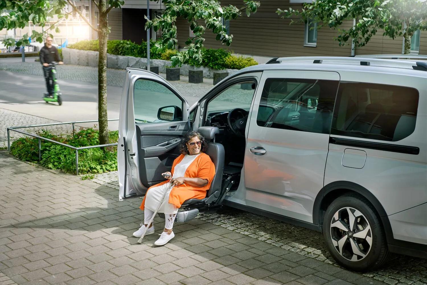 Silver minivan with Turny Evo rotating and lowering passenger seat extended outward