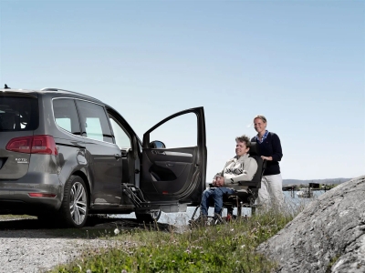 Gray minivan with side-mounted Carony wheelchair transfer system