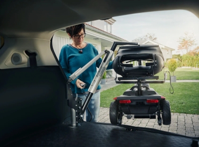 Person using Carolift 100 electric hoist to load mobility scooter