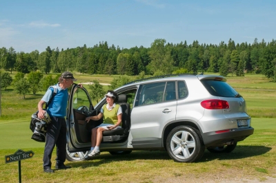 Silver SUV with Turny Evo rotating and lowering passenger seat extended outward on golf course