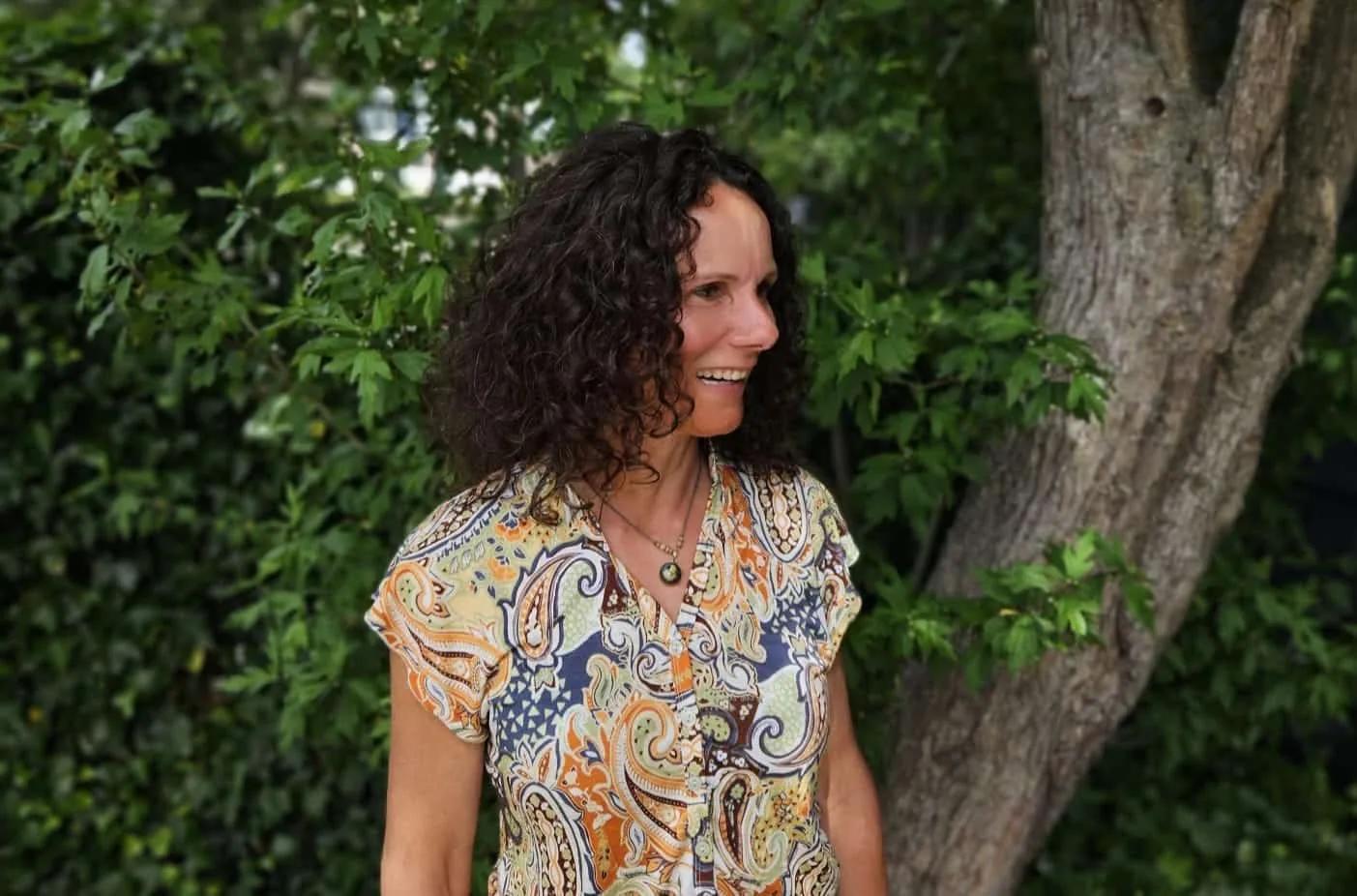 Natascha Verboom buiten in een groene tuin als persoonlijk beeld bij de praktijk
