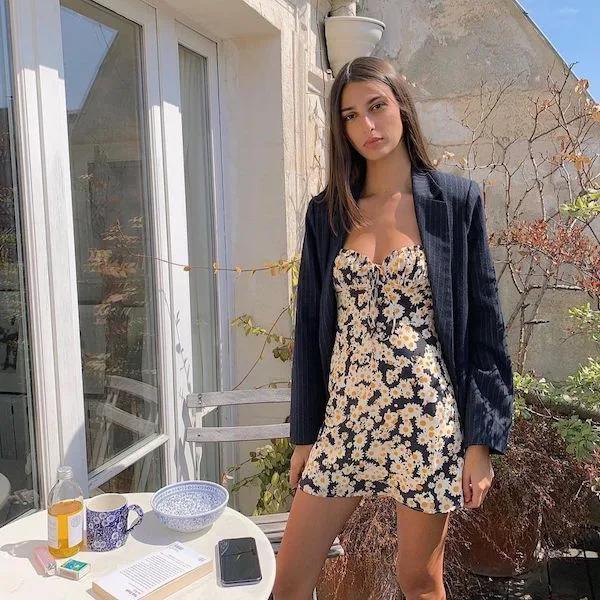 Girl wearing Realisation Par dress with daisy print and a black blazer.