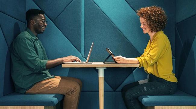 Two team members with their own devices in the office