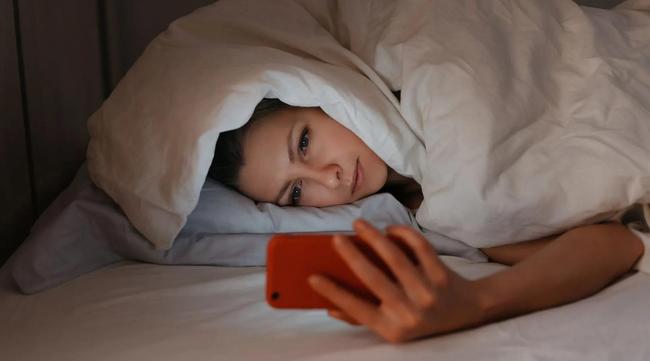 Woman on phone in bed