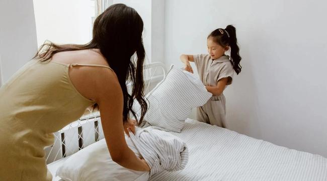Mother and Daughter making bed