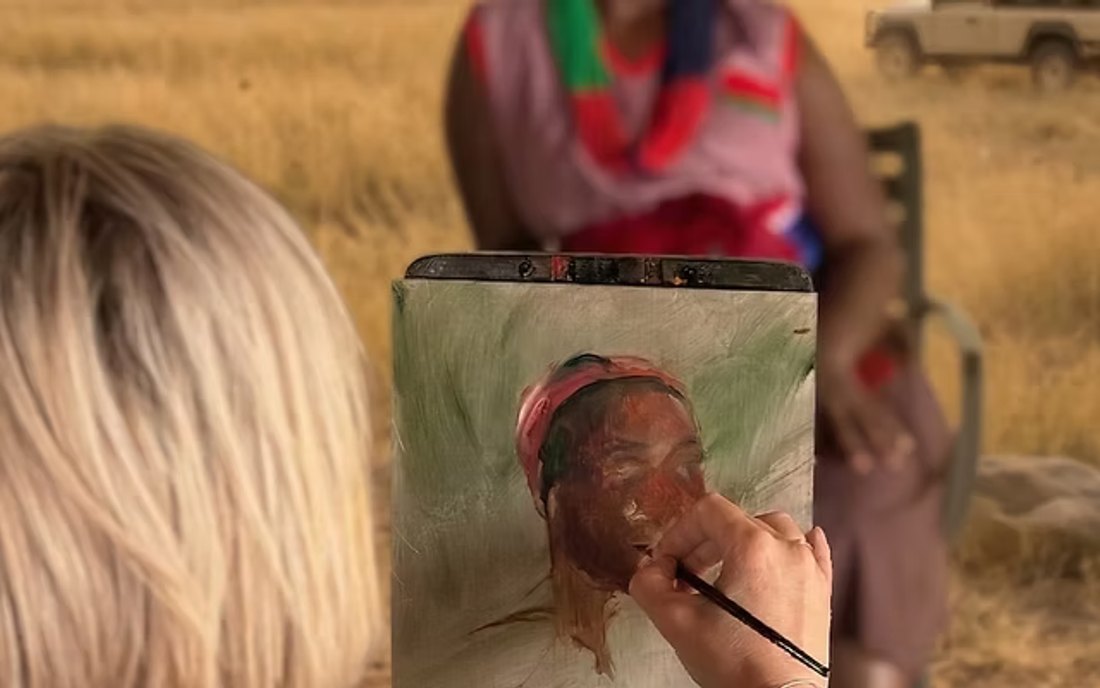 Taléta painting a portrait from life during an outdoor workshop