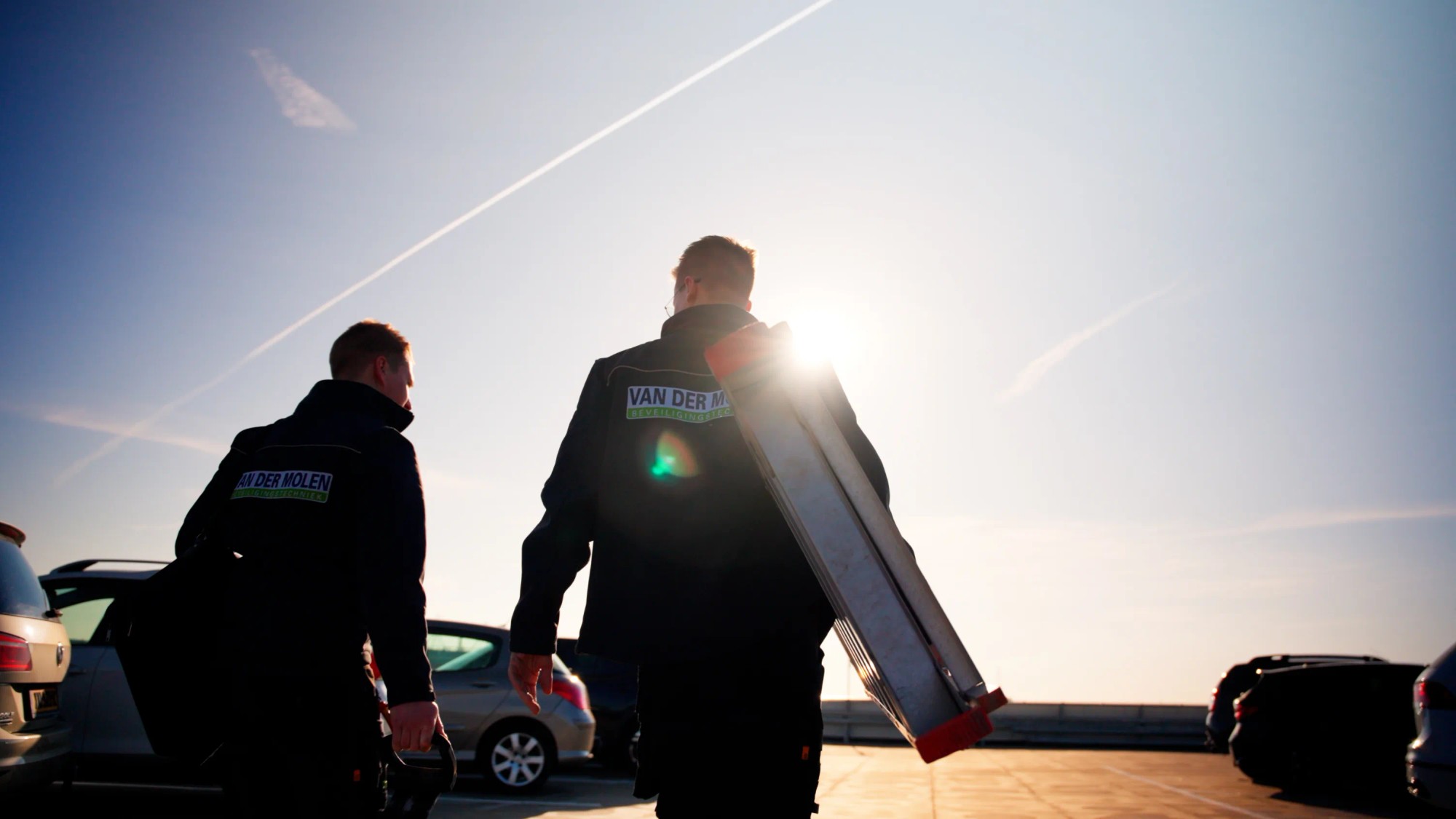 Twee werknemers lopend met ladder