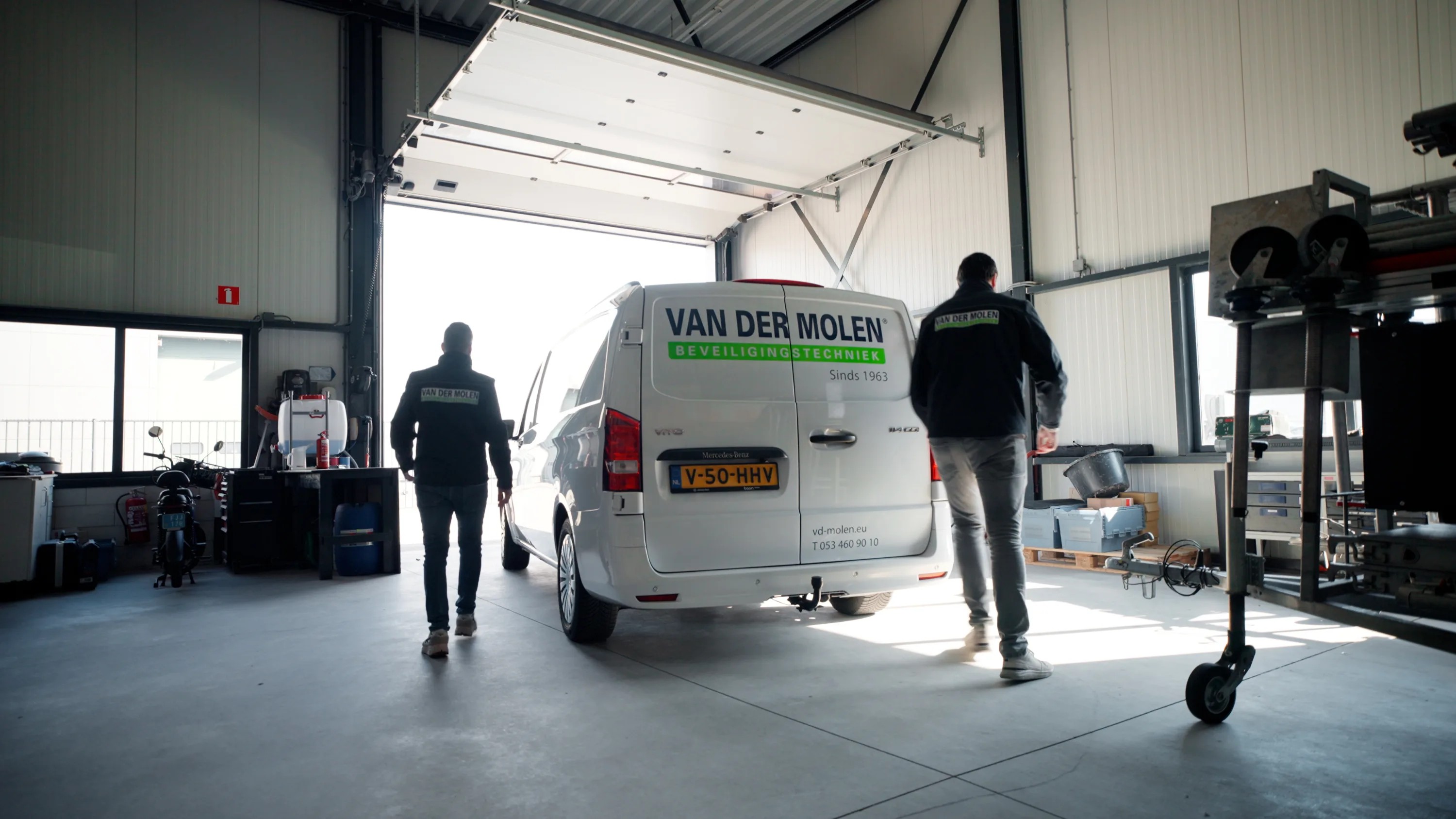 Twee monteurs lopen naar de bedrijfsbus