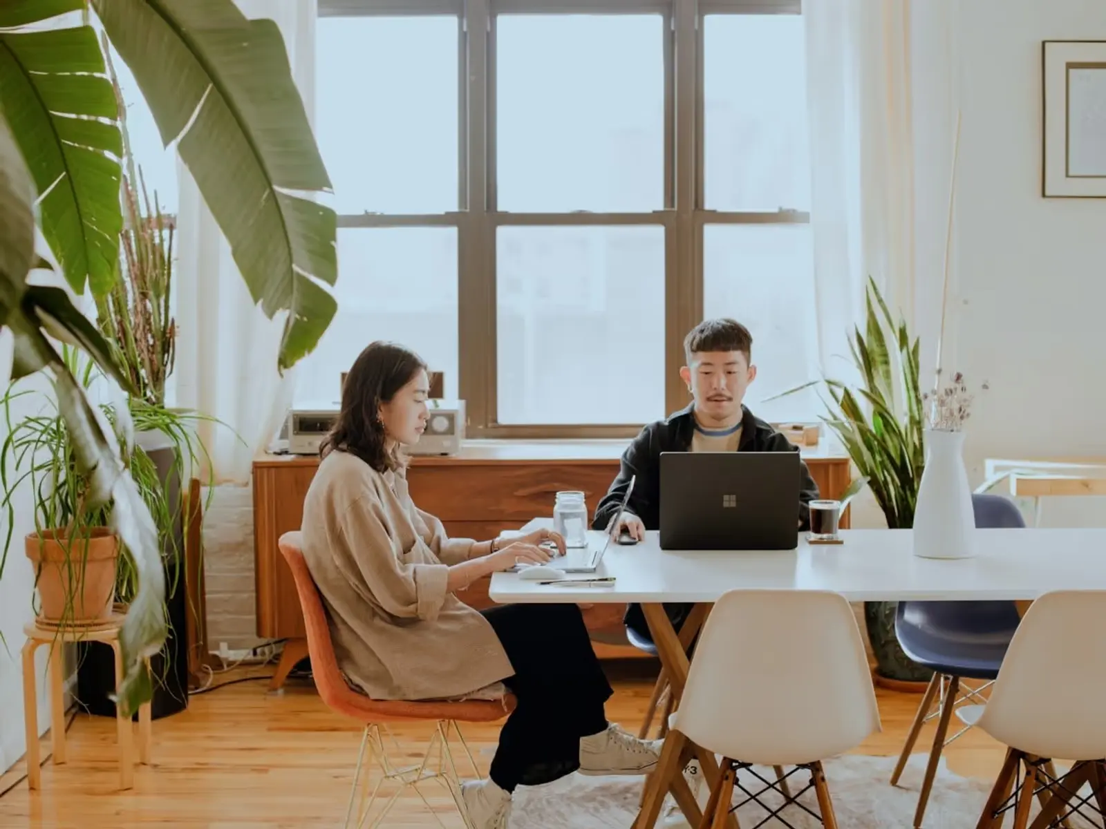Two people sat at a table working alongside each other