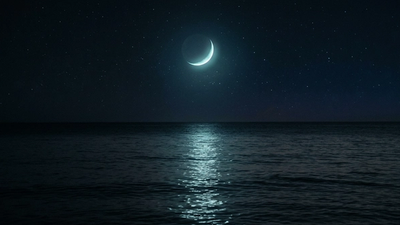 Crescent moon rising over a calm sea at night representing how to find your moon sign in astrology