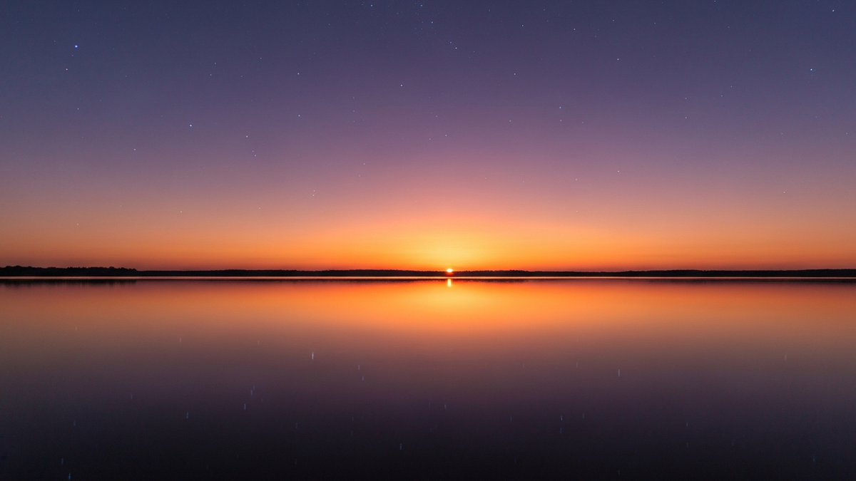 Twelve zodiac symbols arranged in a cosmic circle with golden sunrise light for daily horoscope forecast