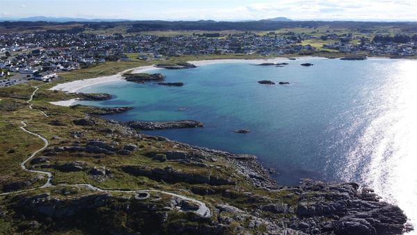 Strand med byen bak, i Karmøy kommune