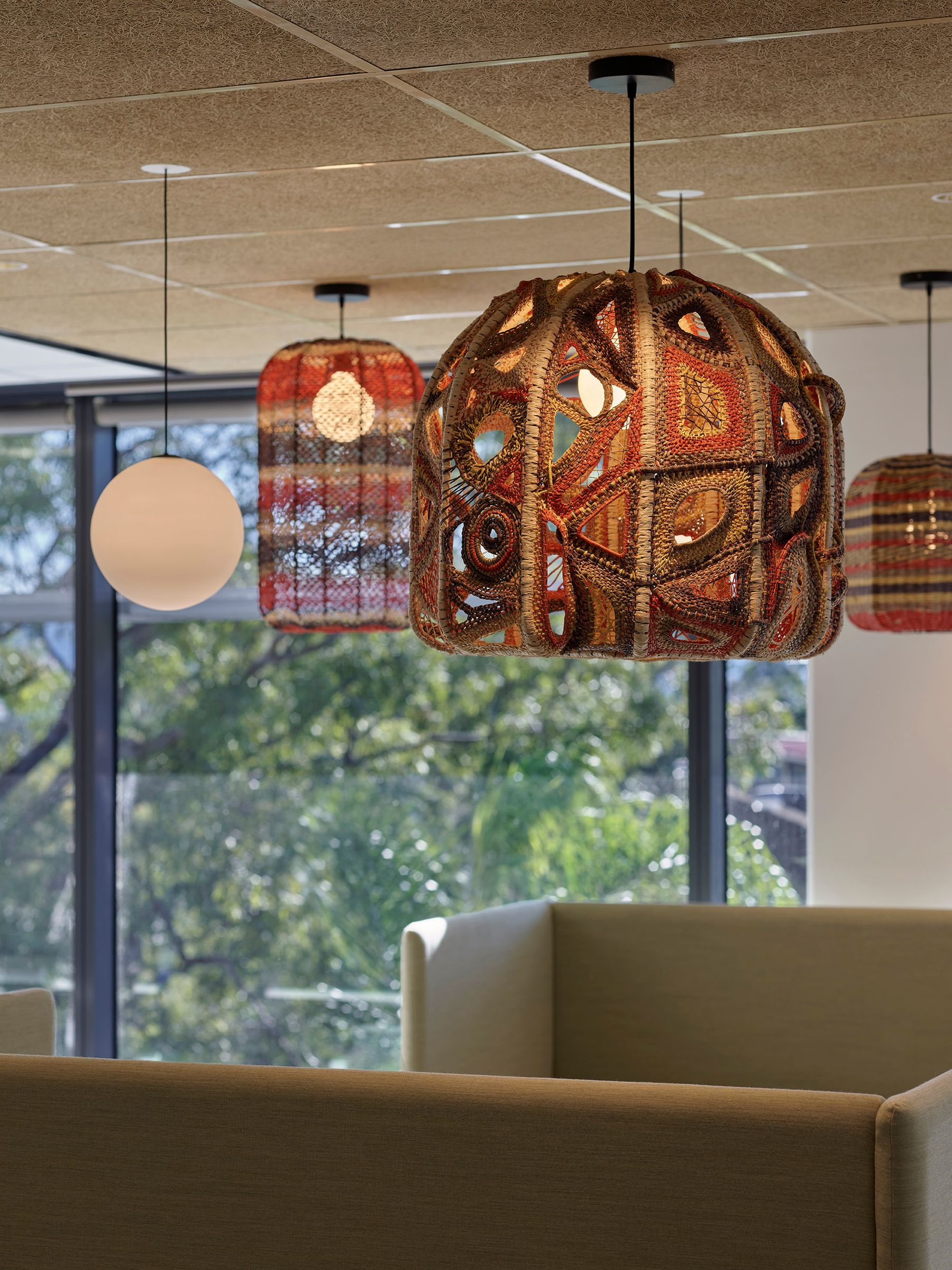 Detailed shots of three woven pendant lights hanging above a seating area.