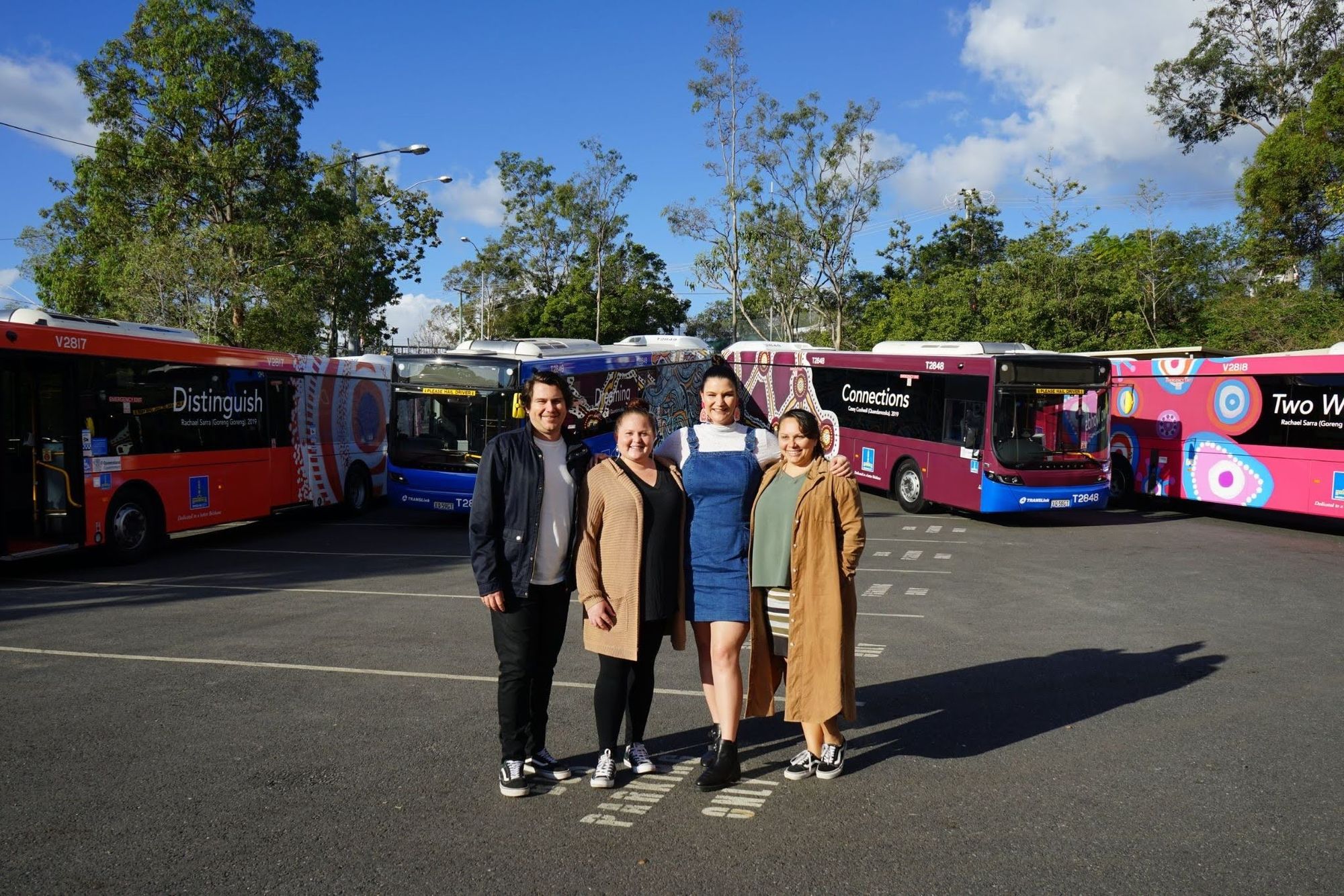roy Casey, Casey Coolwell-Fisher, Rachel Sarra and Amanda Hayman in front of the Brisbane City Council First Nations buses