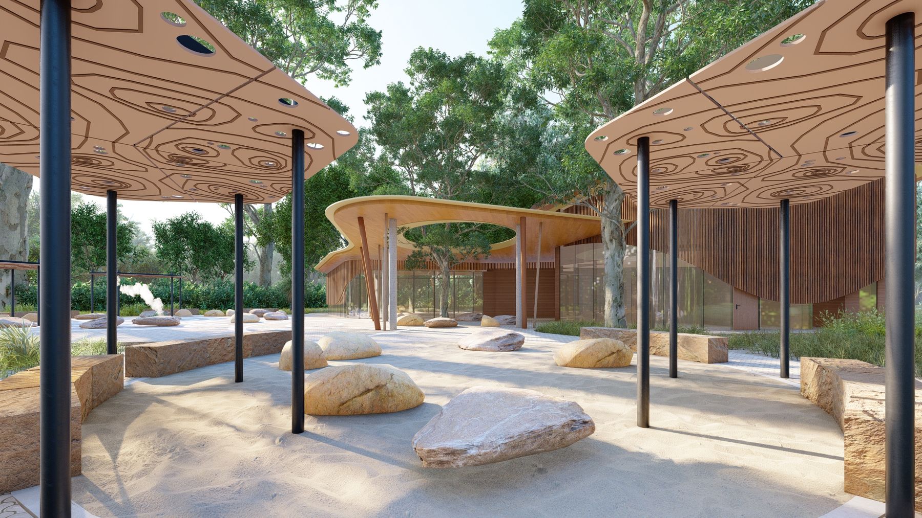 Covered courtyard with patterned paving, sandstone rocks and a tree growing through a roof opening, beside a glass-walled building.