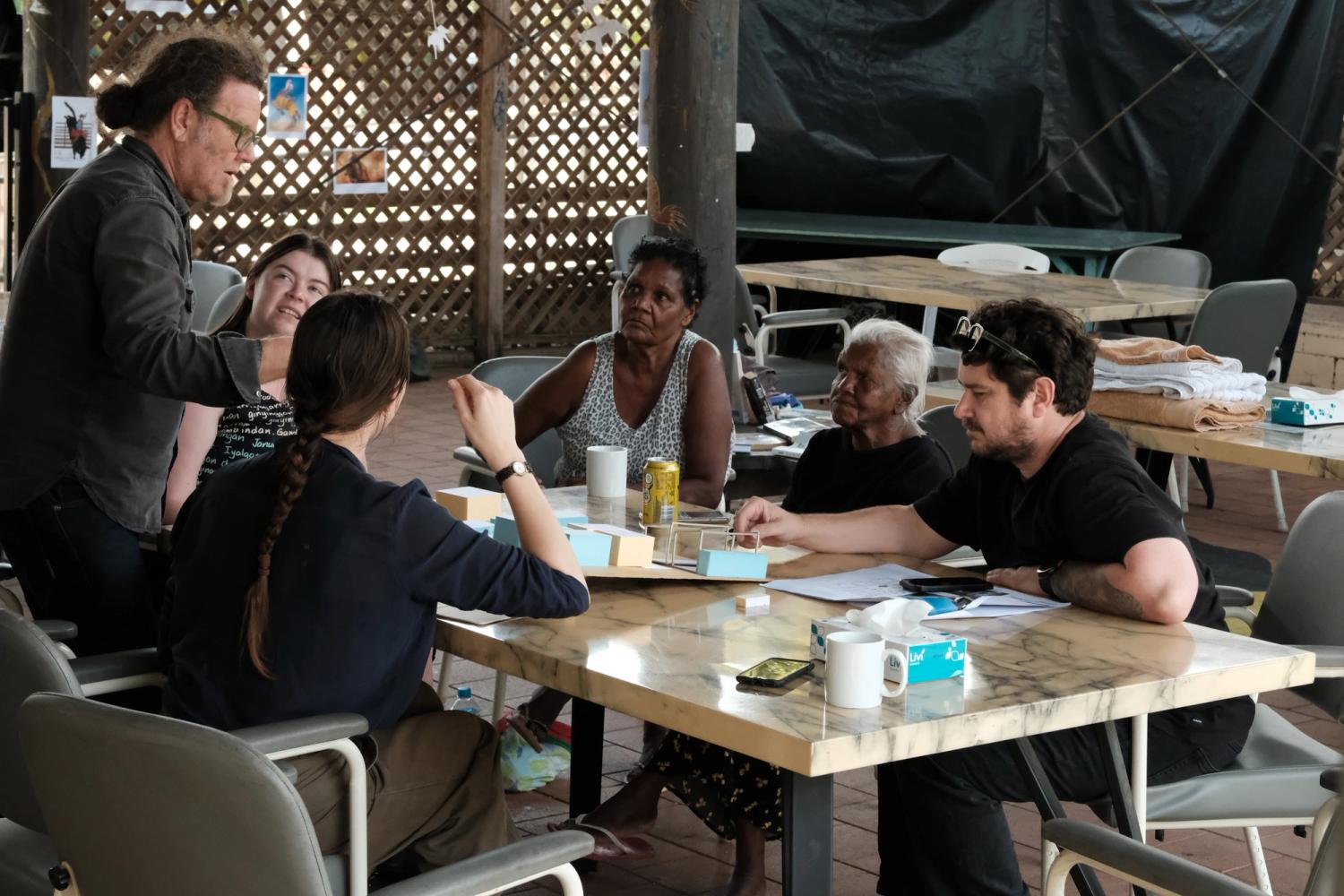 A diverse group of people gathered around a table engaged in a collaborative discussion. 