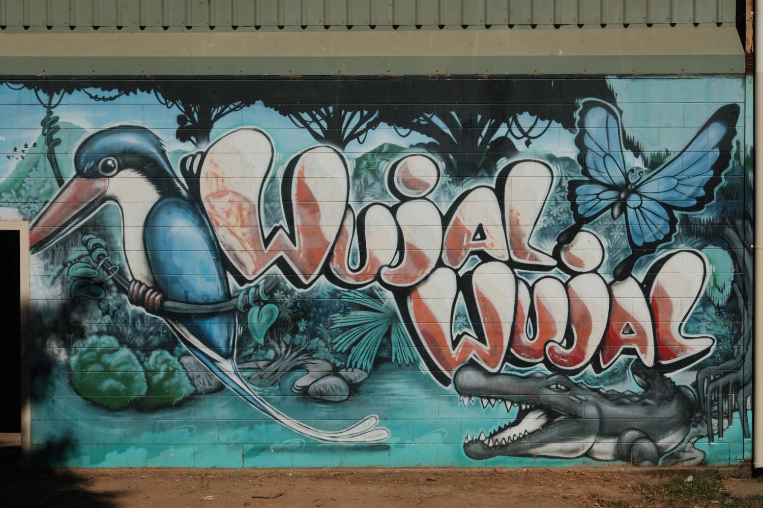 Colourful mural of "Wujal Wujal" featuring a bird, Butterly, crocodile and lush landscape. 