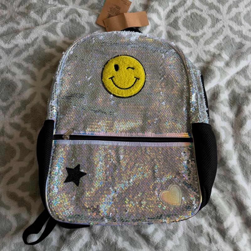 Mochila con lentejuelas plateadas y diseño de carita feliz