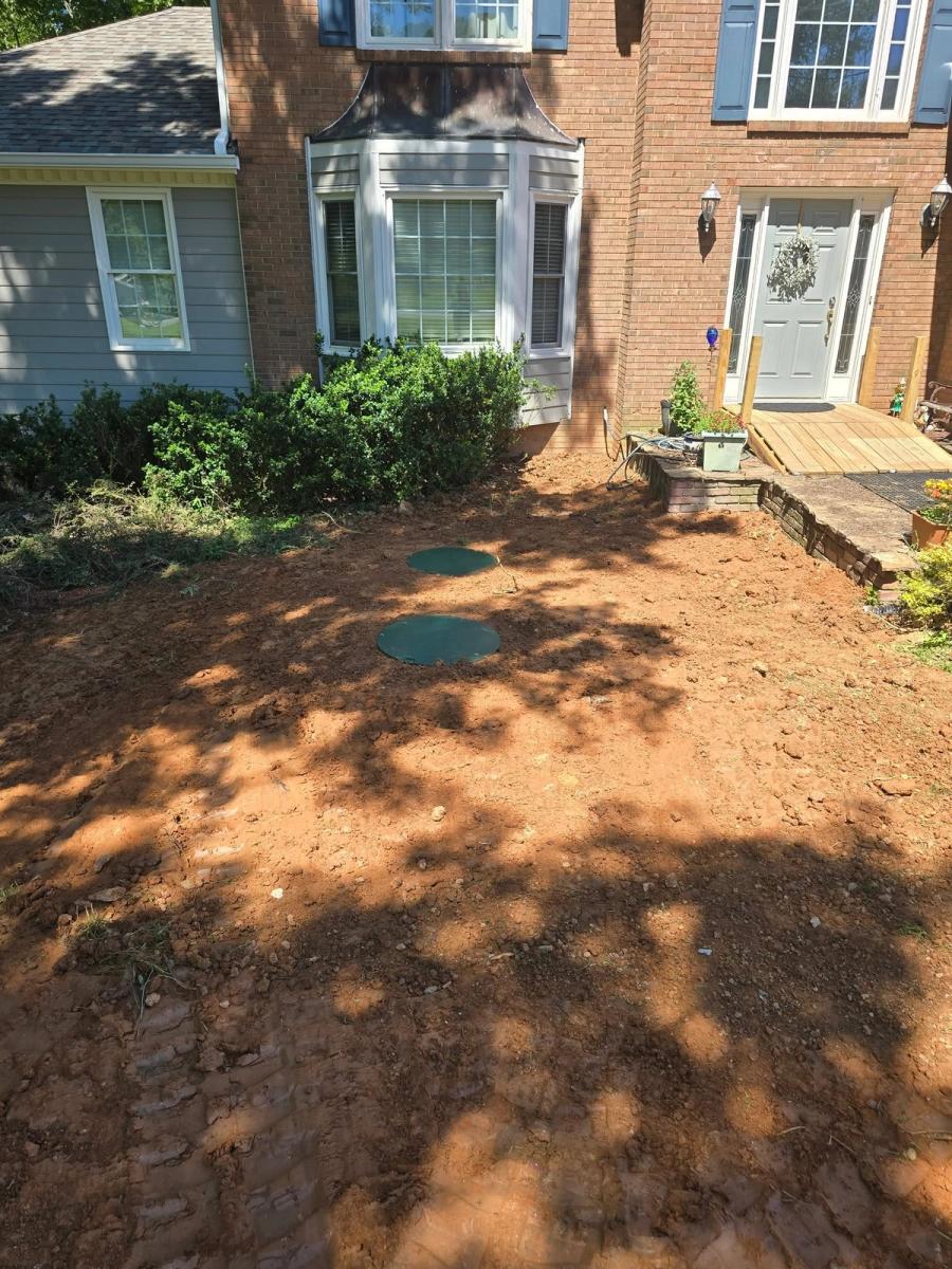 Same front yard backfilled with green tank lids at grade
