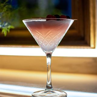 Cocktail rosa in coppa Martini sul bancone