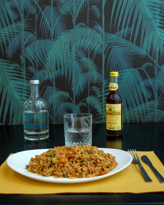 Riso saltato con verdure e un chinotto sulla tovaglietta gialla