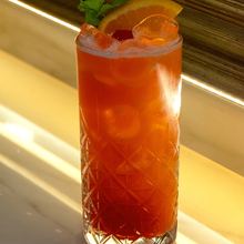 Cocktail all'arancia con menta sul bancone illuminato