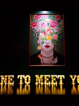 Il quadro della donna con i fiori tra i capelli sopra l'insegna luminosa Wine to meet you
