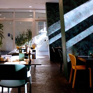 La sala con le sedie gialle e la carta da parati a foglie di palma