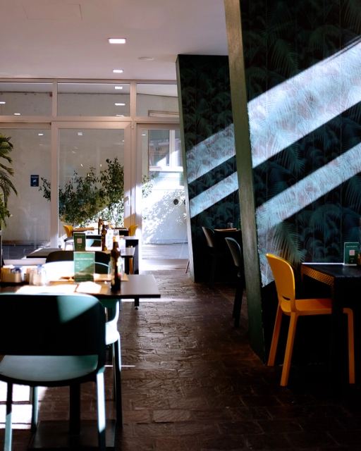 La sala con le sedie gialle e la carta da parati a foglie di palma