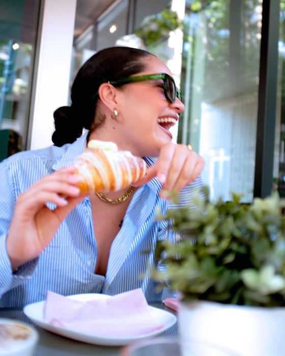 Una cliente ride mentre mangia un cornetto