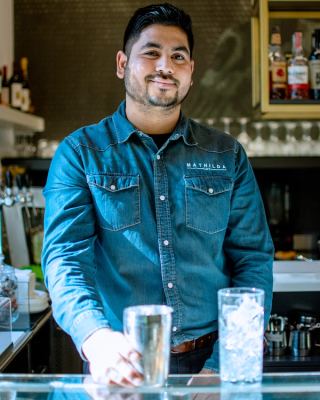 Il bartender di Mathilda sorride dietro al bancone