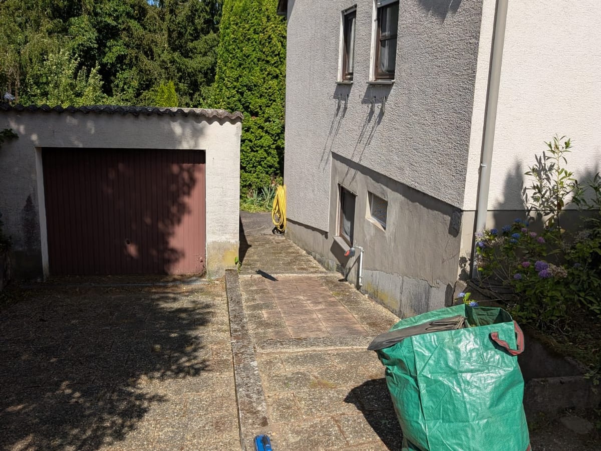 Gereinigter Hof mit Laubbläser und Gartensack